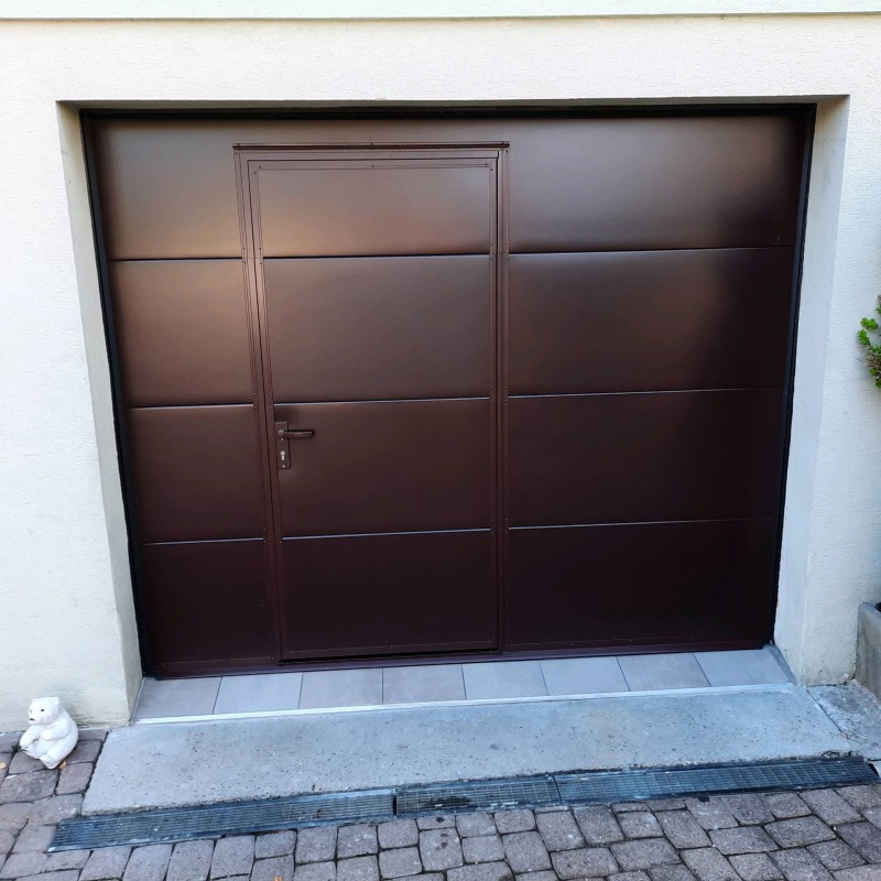 Installation d'une porte de garage sectionnelle isolante avec portillon de couleur chocolat dans le village de Raedersheim